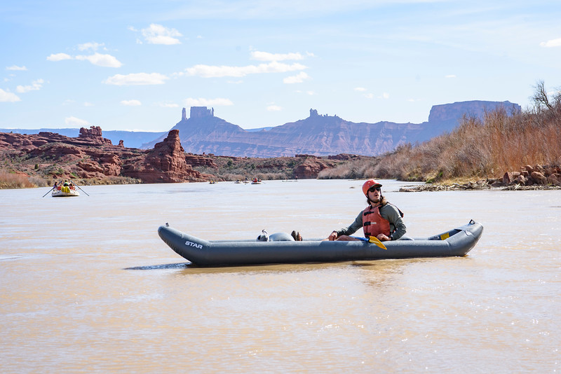 Kayaker admiring the scenery with the bluffs and spires of Castle Valley in the background in Moab, Utah - Mild to Wild