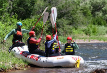 Rafters hold up their paddlers to each other in the boat on the San Miguel River - Mild to Wild