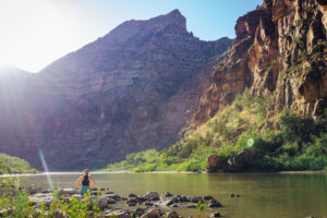 Woman sitting on Green River bank in Desolation Canyon - Mild to Wild