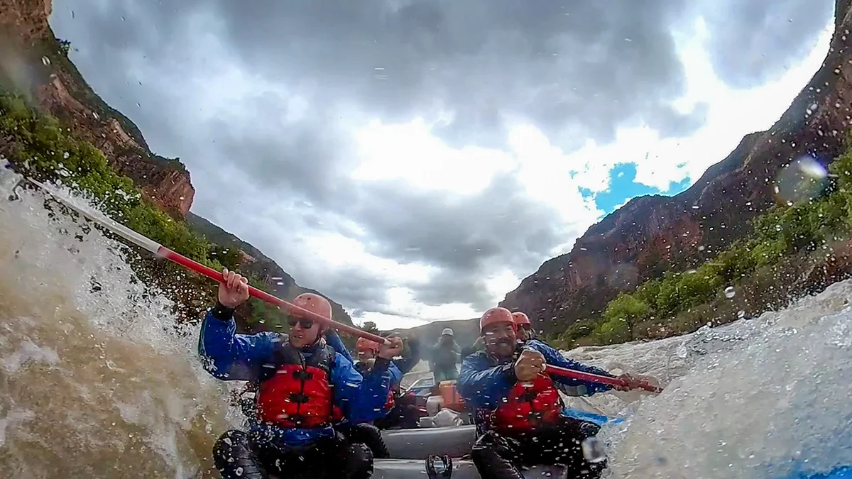 An up-close shot of a rafting group paddling through rapids